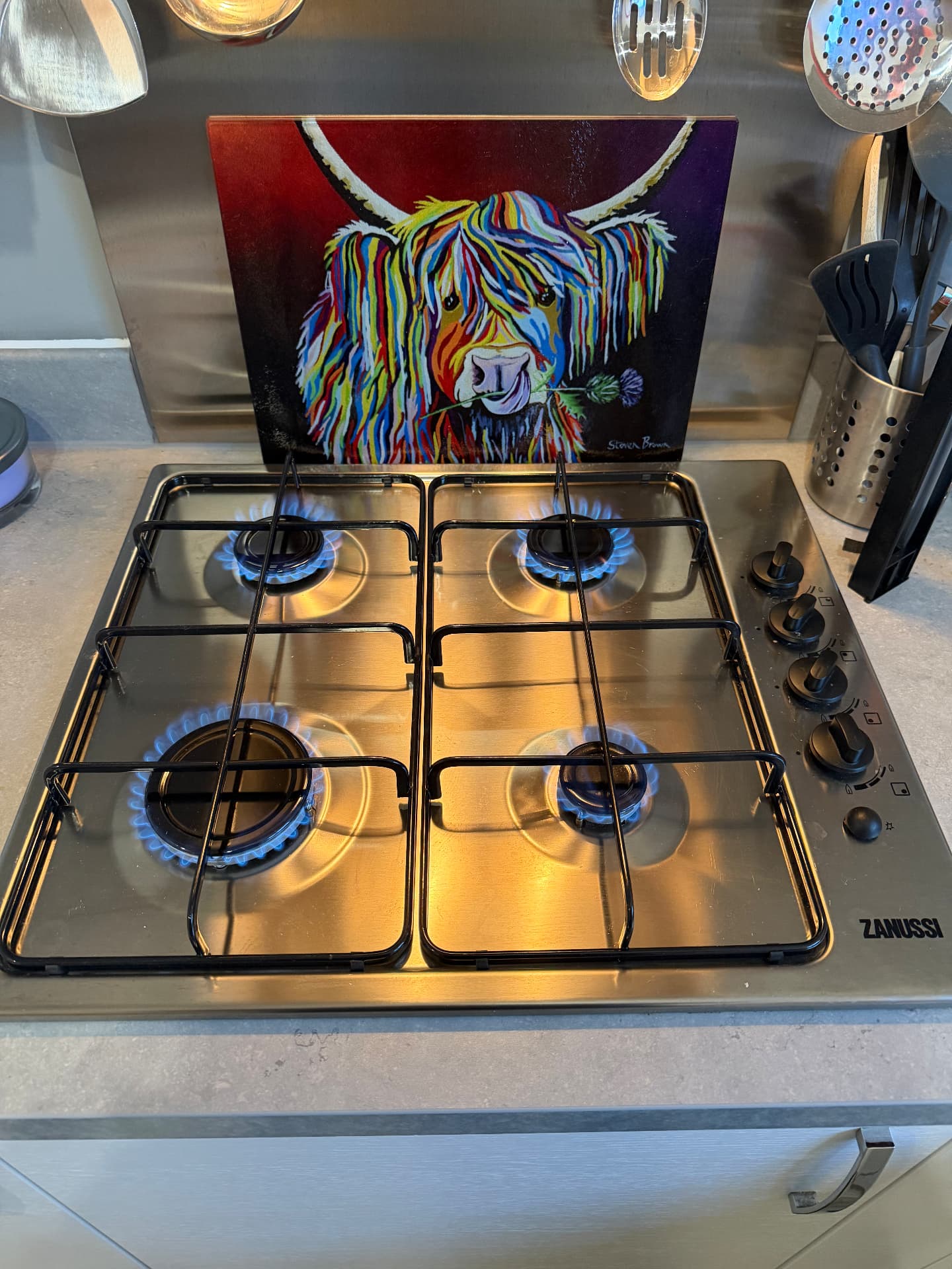 Four-burner stainless steel gas hob lit and tested after installation