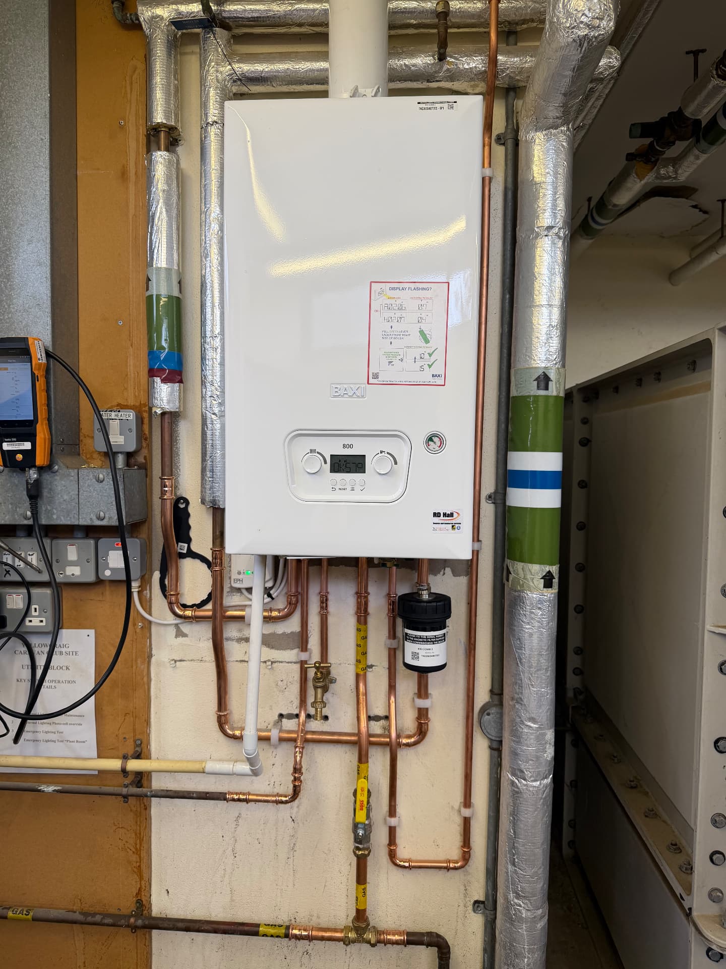 Commercial plant room boiler installation with gas-marked copper pipework and insulated ducting