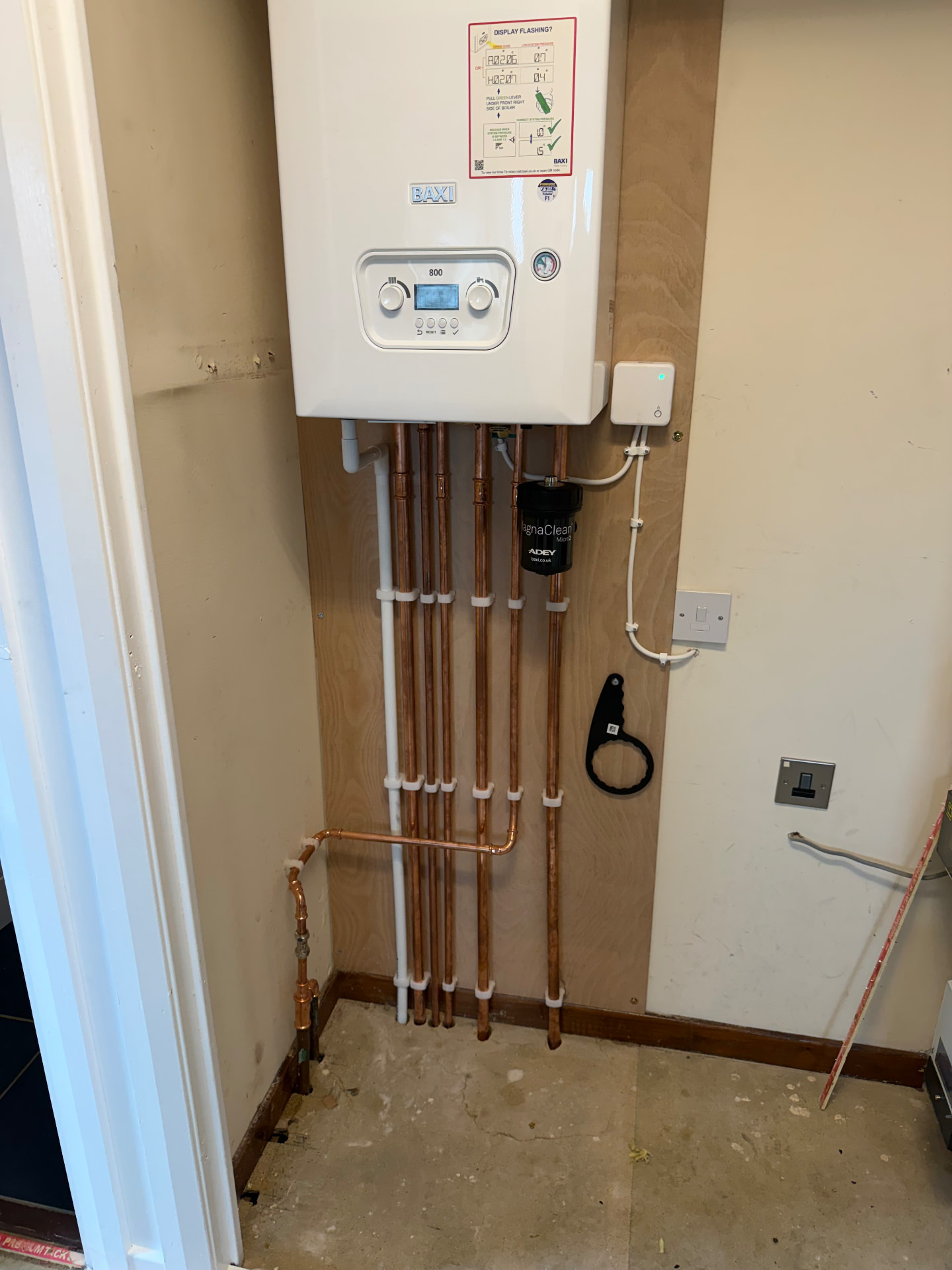 Baxi 800 combi boiler installed in a utility cupboard with neat copper pipework and a MagnaClean filter
